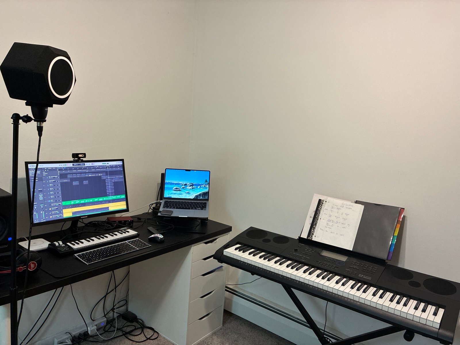 desk, piano keyboard, mic and mic stand, macbook, home studio setup for gospel artists